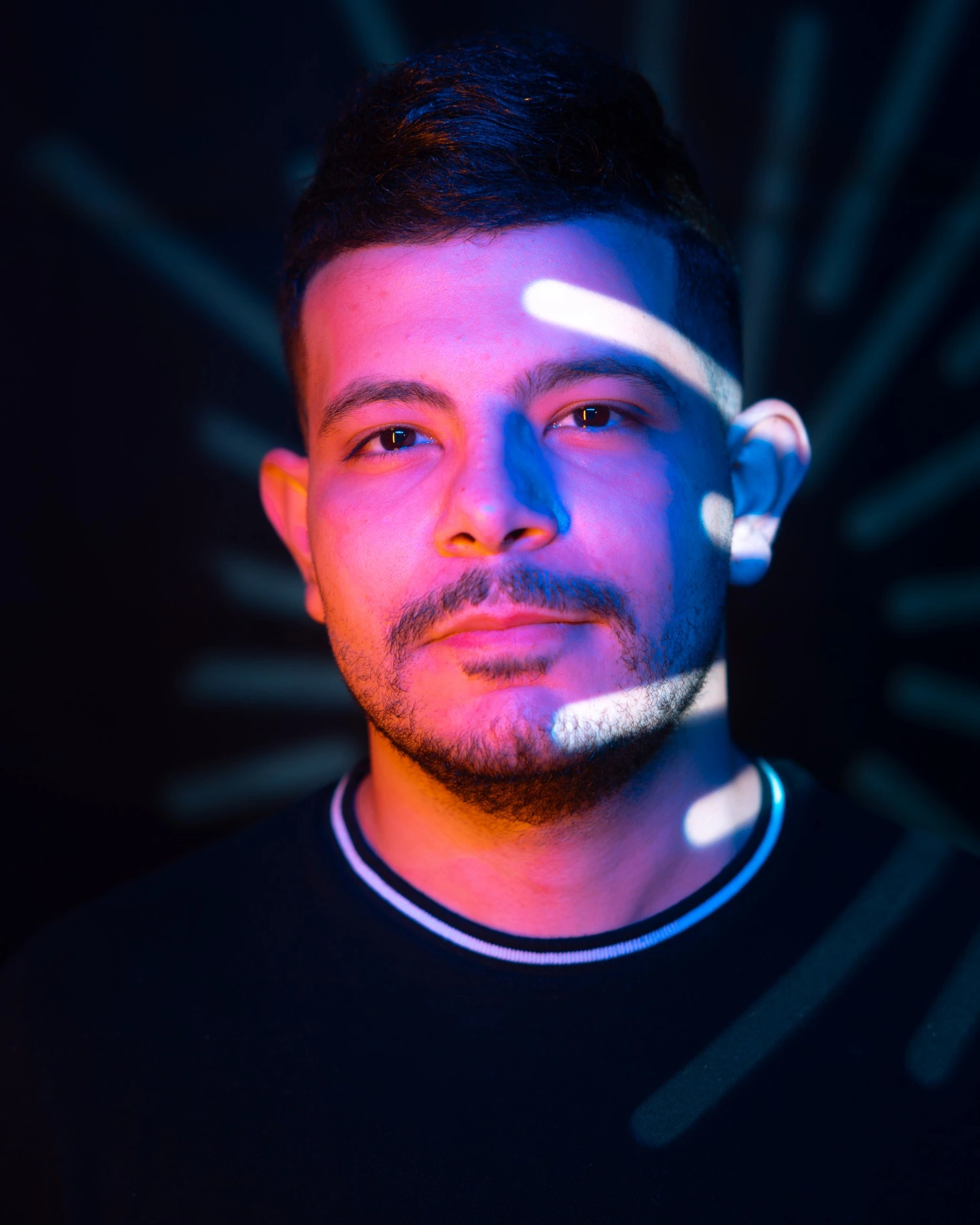 Portrait of Mohamed Saeed lit in pink and blue light