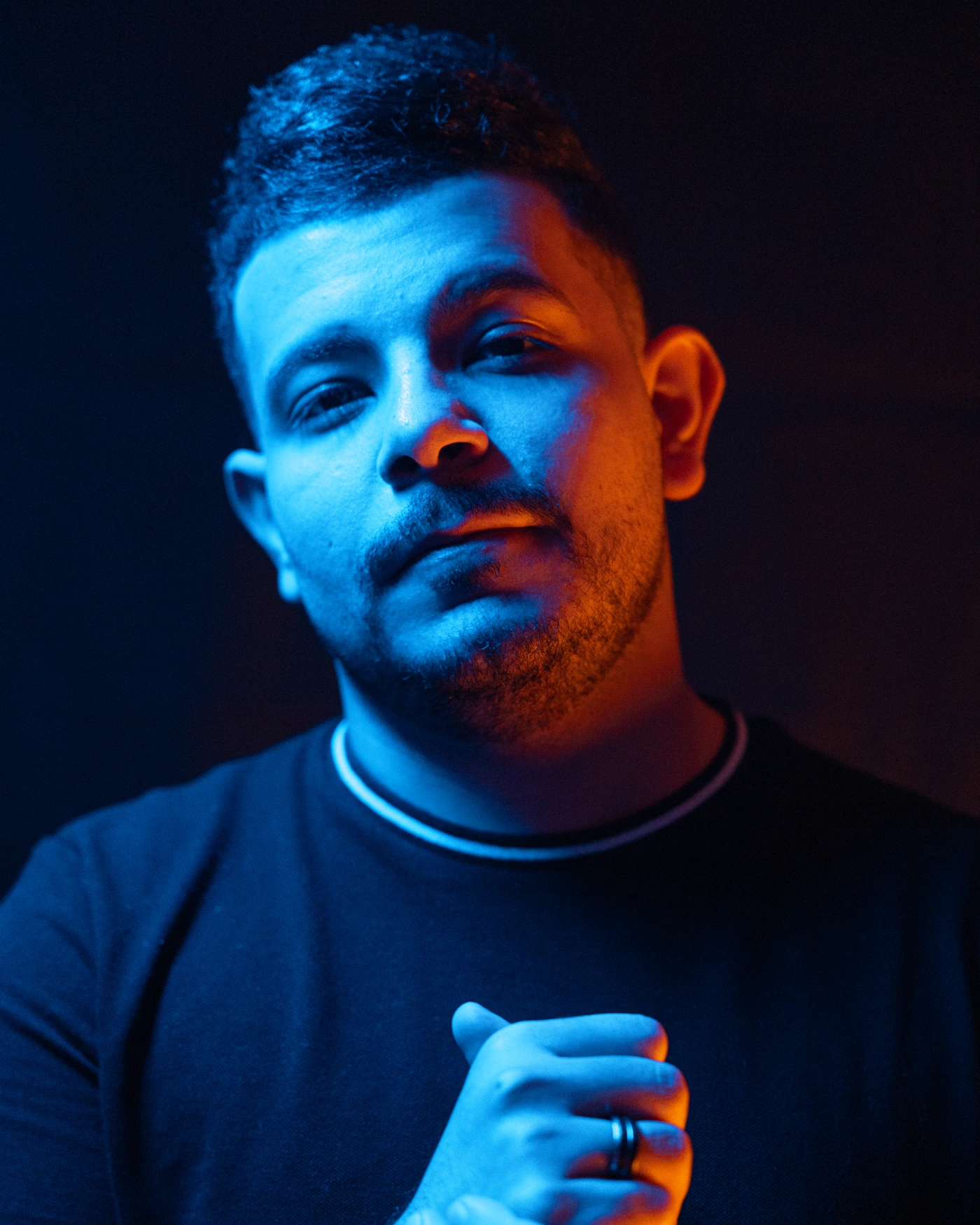 Portrait of Mohamed Saeed lit in blue and orange light